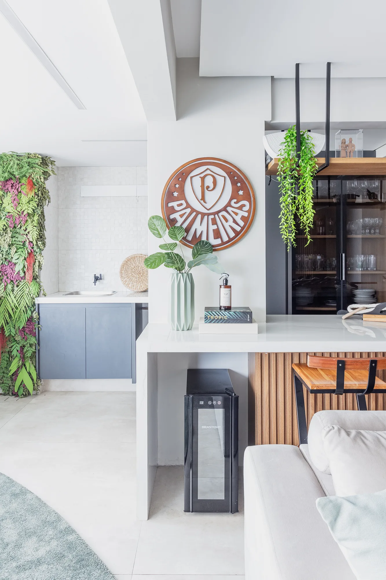 Espaço gourmet com jardim vertical, adega e bancada branca