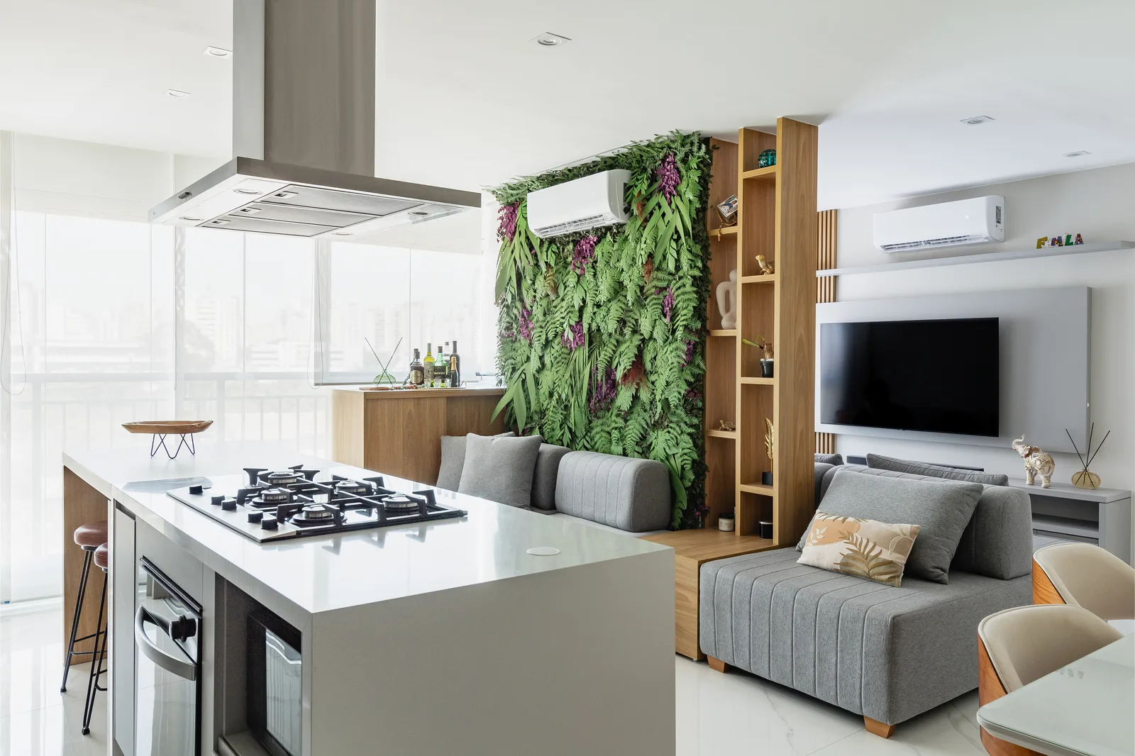 Living integrado à cozinha, com jardim vertical e vista da cidade