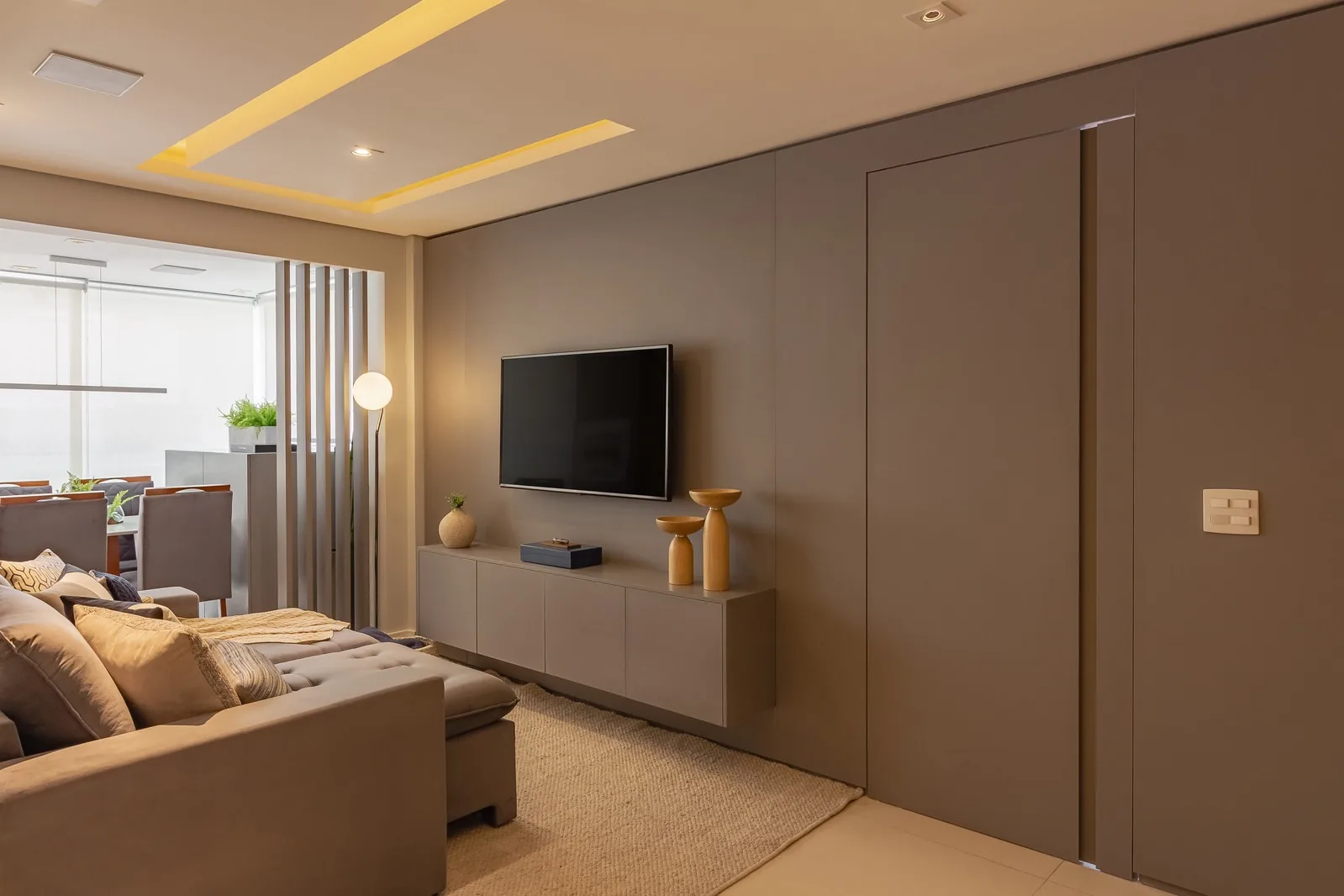 Sala de estar do Projeto AR com painel de TV e ripas de madeira